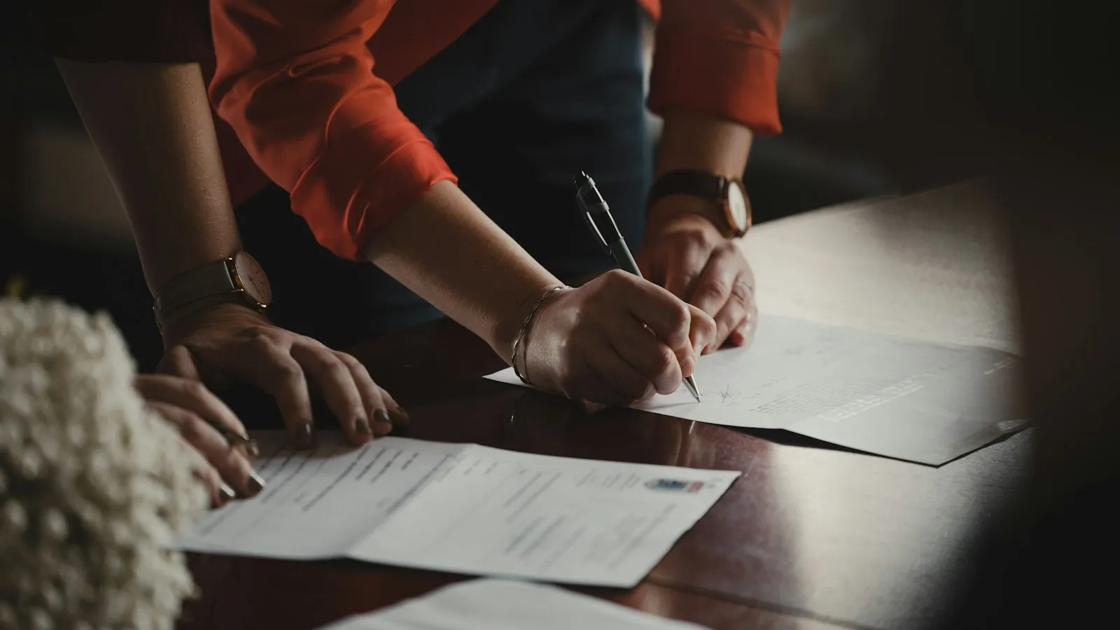 Persona firmando los documentos de registro de su negocio ante la Cámara de Comercio