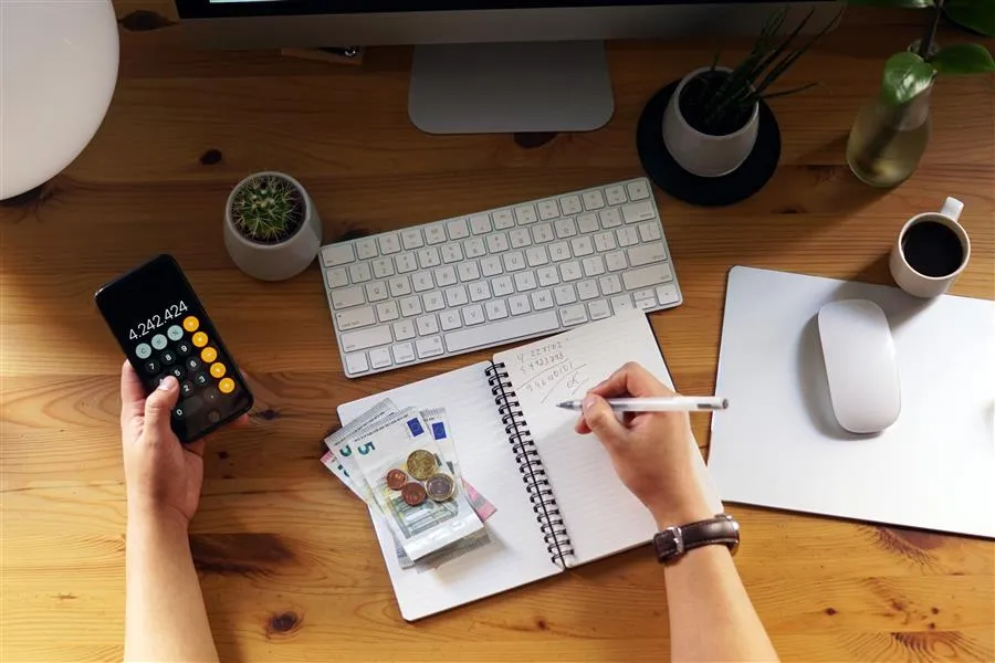 Persona revisando sus finanzas personales desde casa con calculadora